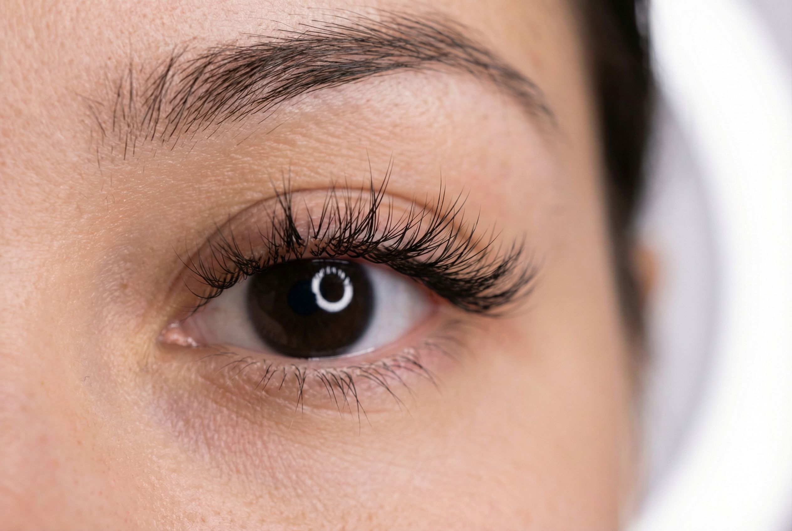 Close-up of wispy lash extensions showing textured, spiky, varied-length finish